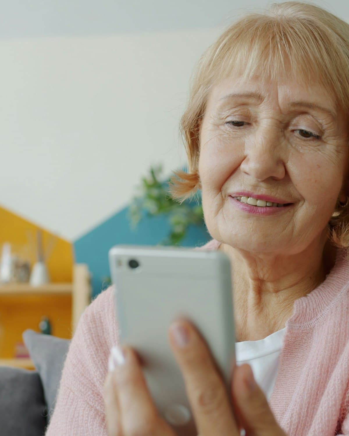 An older woman smiling as she takes a phone call at home